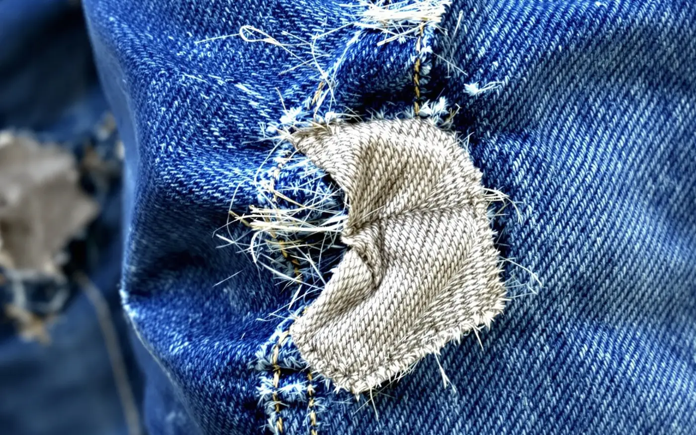 Jean usé à l'entrejambe : la toile s'est déchirée le long de la couture